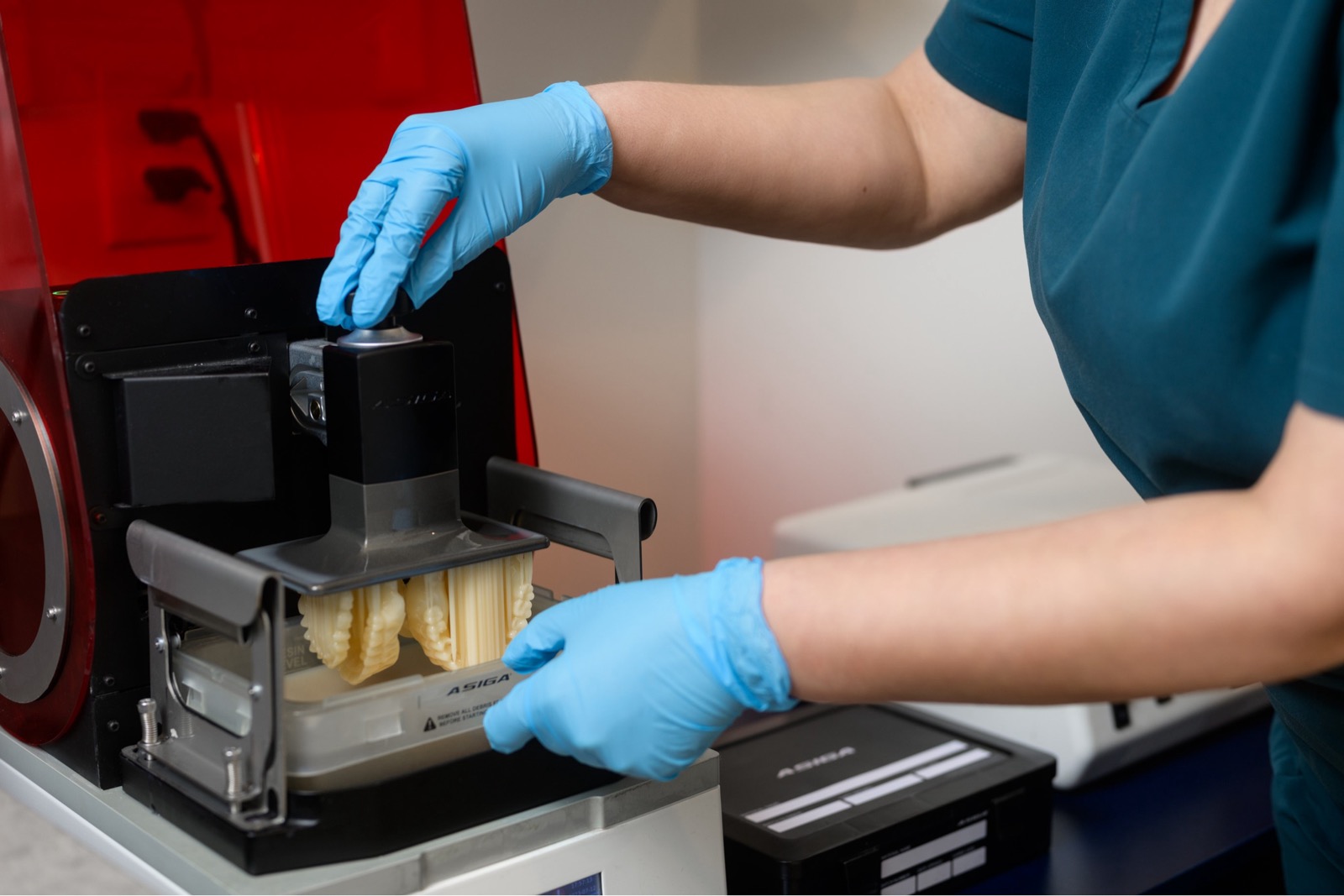 Gloved hands holding a digitally produced dental arch